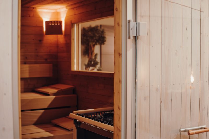 Sauna mit Holzbänken und Fenster ins Grüne